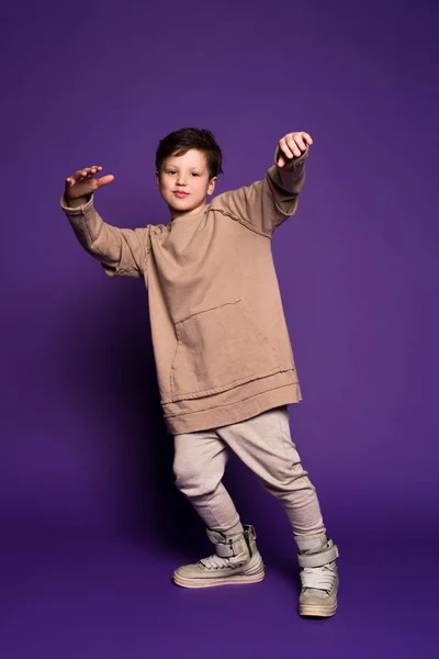 ¡El estilo es más acerca de ser tú mismo! Joven niño sonriente con chaqueta de lana beige ranurado y tener un tiempo maravilloso durante sus vacaciones . — Foto de Stock