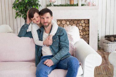 Babalar çocuklarının yaşamlarında aktif katılımcılar olmak arzusu olmalı! Müteşekkir çocuk babasının boyun, silah o kanepede otururken twining.