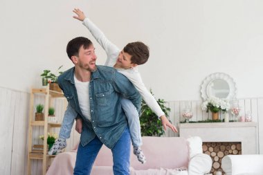 Harika bir baba biri olan çocukların ona bak! Büyük bir zevk ile ücretsiz onun vakit babasının sırtına oturan genç çocuk uçan.