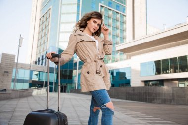 Bin mil yolculuk tek bir adımla başlar! Fly away için bavulunu Havaalanı yakınında ayakta, gidiş trendy yakışıklı güzel Bayan.