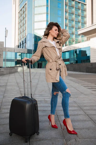 ¡El mundo es un libro y los que no viajan leen solo una página! Retrato de cuerpo entero de la joven bien adornada mientras se ve muy de moda y sostiene el equipaje, va a viajar al extranjero . — Foto de Stock