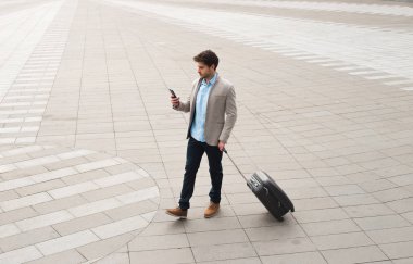 Profesyonellik içeride! Genç işadamı, Bagaj belirlenmesi ve güven ile çalışma rutin ile açık havada yürüyüş.