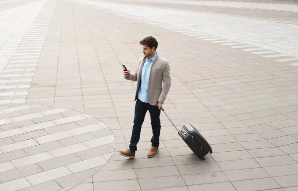 ¡El profesionalismo está dentro! Joven hombre de negocios caminando al aire libre con equipaje en la rutina de trabajar con determinación y confianza . —  Fotos de Stock