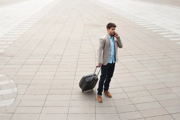 Communication d'affaires ! Portrait corporel complet d'un beau voyageur d'affaires masculin sérieux marchant avec un sac et décidant de certains problèmes en parlant téléphone . — Photo