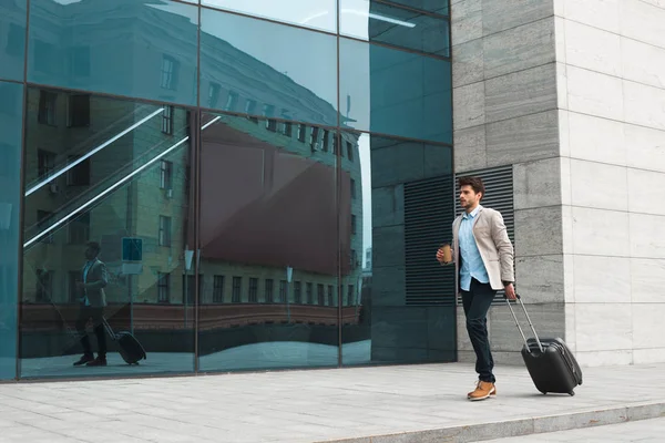 Vol d'affaires ! Photo pleine longueur d'un jeune homme d'affaires génial portant ses bagages à l'aéroport et buvant du café à emporter après un voyage d'affaires . — Photo