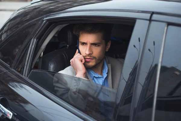 ¡Con mentalidad financiera! Primer plano retrato del guapo joven empresario serio hablando por teléfono inteligente, mientras que va al aeropuerto en taxi . — Foto de Stock