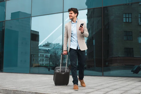 Faites votre travail plus vite ! Photo pleine longueur de l'homme joyeux et joyeux qui va au voyage d'affaires et marche avec sa valise . — Photo