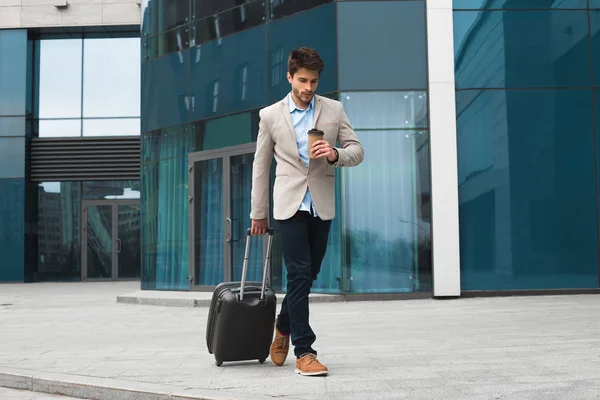 ¡El verdadero empresario es un hacedor! Vista del joven hombre de negocios guapo con equipaje en el aeropuerto internacional bebiendo café después de un largo viaje de negocios . — Foto de Stock