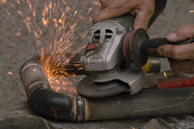 çalışan bir metal boru Zımpara aleti keser.