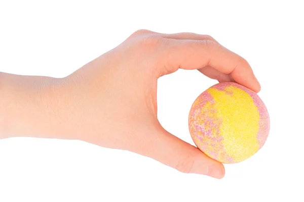 Female hand holding a yellow pink bath ball — Stock Photo, Image