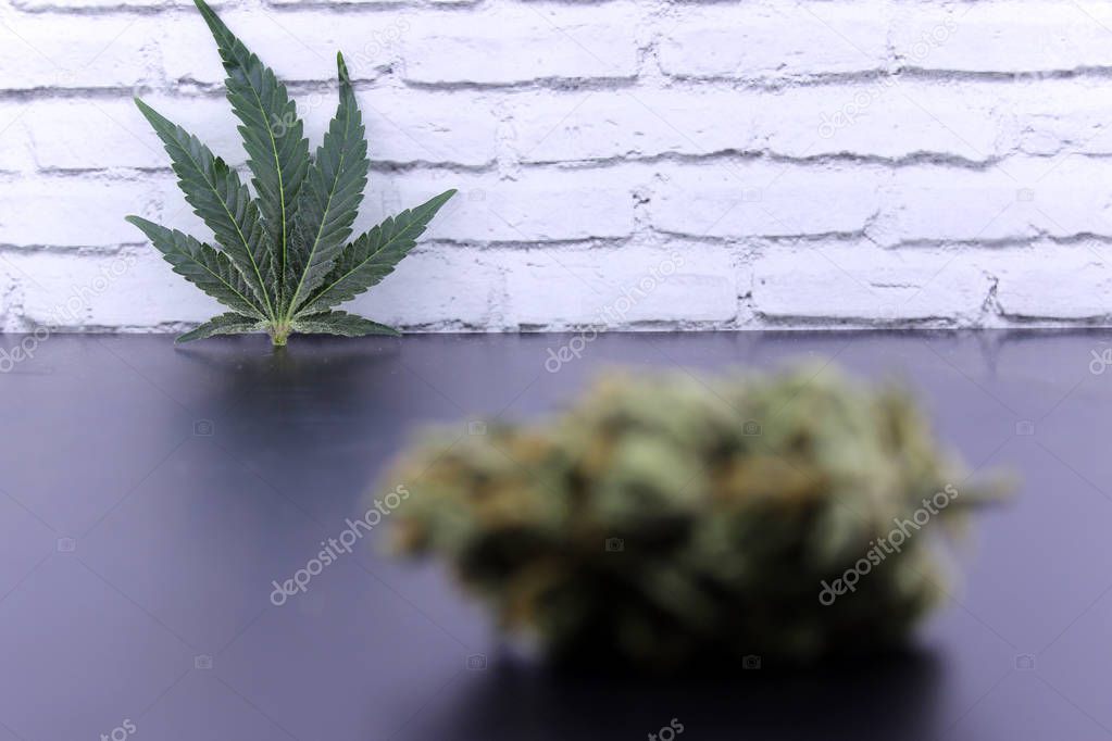 Unfocused cannabis bud and marijuana leaf