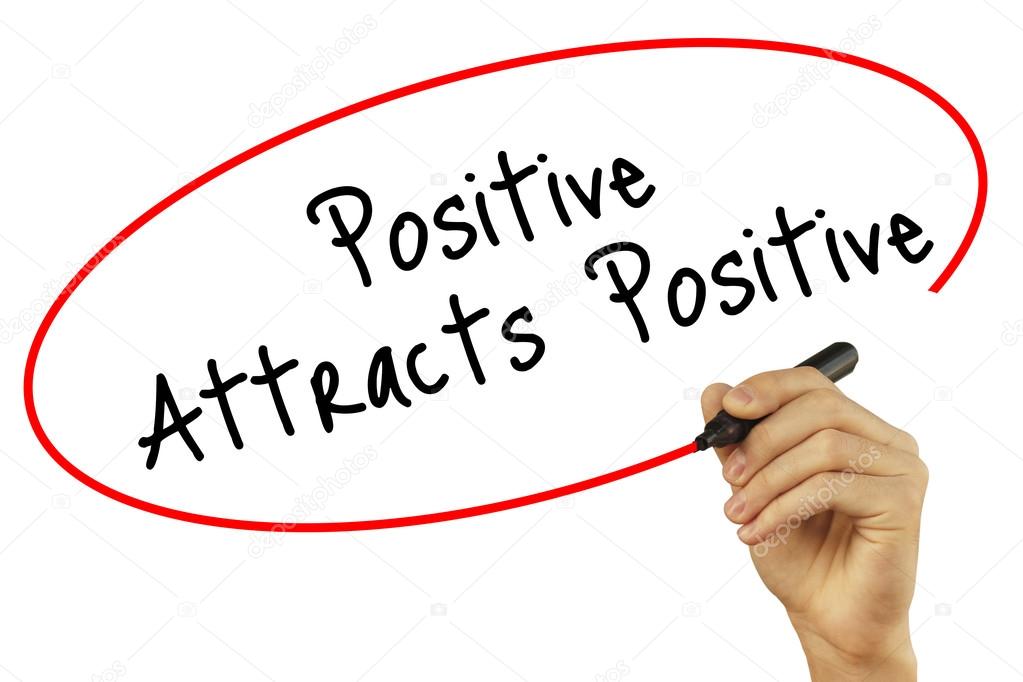 Man Hand writing Positive Attracts Positive with black marker on