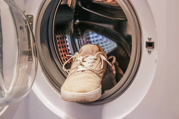 Грязные белые кроссовки в стиральной машине — стоковое фото