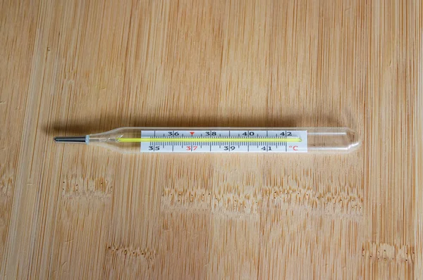 Термометр ртути на деревянном столе — стоковое фото
