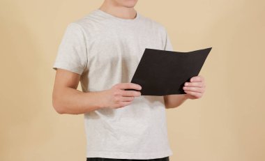 Siyah A4 kağıt tutan adam. Okuyun kitapçığın. Broşür tanıtımı. 