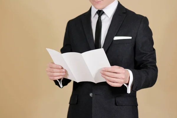 Um homem a mostrar folheto preto em branco. Leia o folheto detalhado. L — Fotografia de Stock