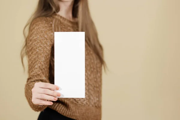 Девушка показывает брошюру с белым флаером. Брошюра — стоковое фото