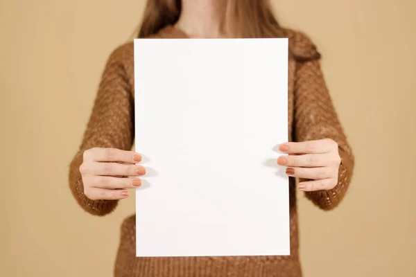 Menina segurando papel branco A4 em branco verticalmente. Apresentação do folheto — Fotografia de Stock