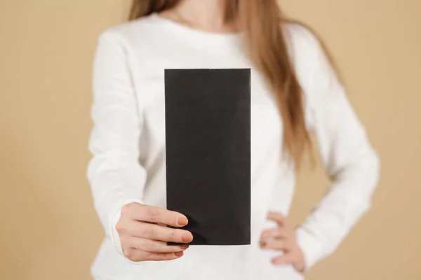 Девушка показывает брошюру черного флаера. Брошюра — стоковое фото