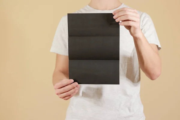 Человек, показывающий брошюру черного флаера. Подробный буклет. Листок — стоковое фото
