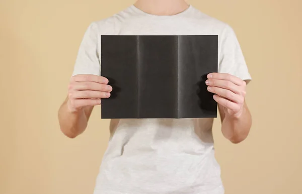 Man showing blank black flyer brochure. Detailed booklet. Leafle — Stock Photo, Image