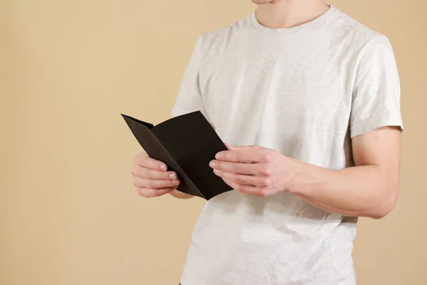 Um homem a mostrar folheto preto em branco. Leia o folheto. Folheto informativo — Fotografia de Stock
