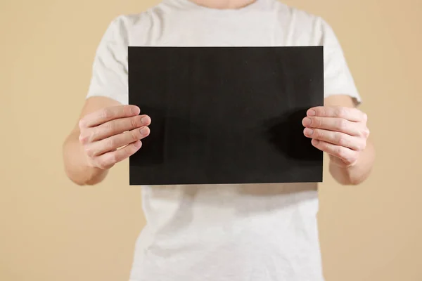Homme tenant du papier A4 noir horizontalement. Présentation du dépliant. P — Photo