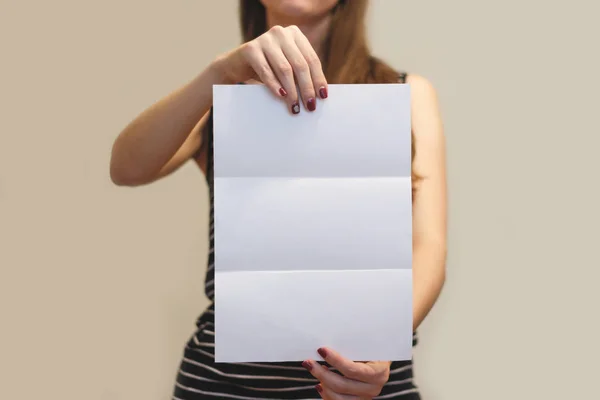 Дівчина, що показує порожній білий брошура-фуршет. Листковий подарунок — стокове фото