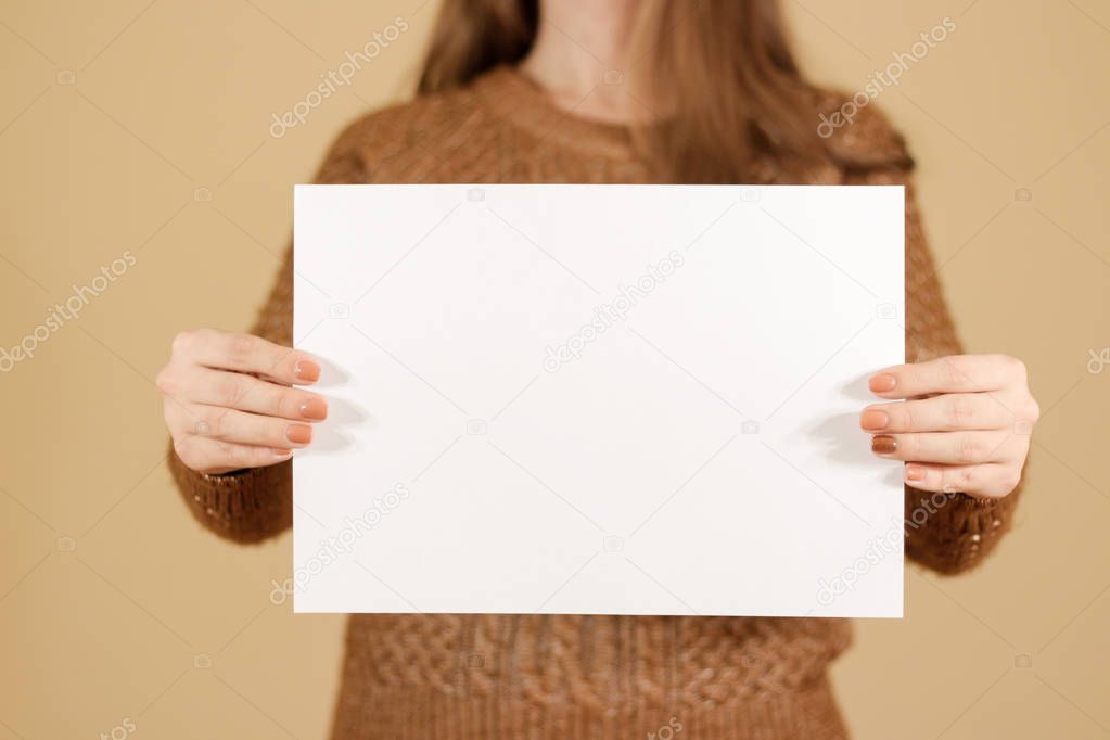 Girl holding white blank paper horizontally. Leaflet presentatio