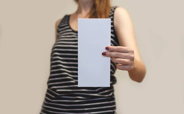 Menina mostrando folheto de folheto branco em branco. Folheto presente — Fotografia de Stock