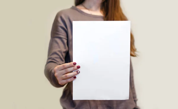 Девушка держит белую пустую бумагу А4 вертикально. Leaflet presentati — стоковое фото