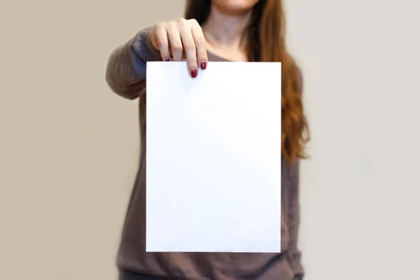 Chica sosteniendo papel blanco A4 en blanco verticalmente. Folleto presentati — Foto de Stock