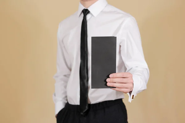 Homem mostrando folheto em branco folheto preto. Apresentação do folheto — Fotografia de Stock