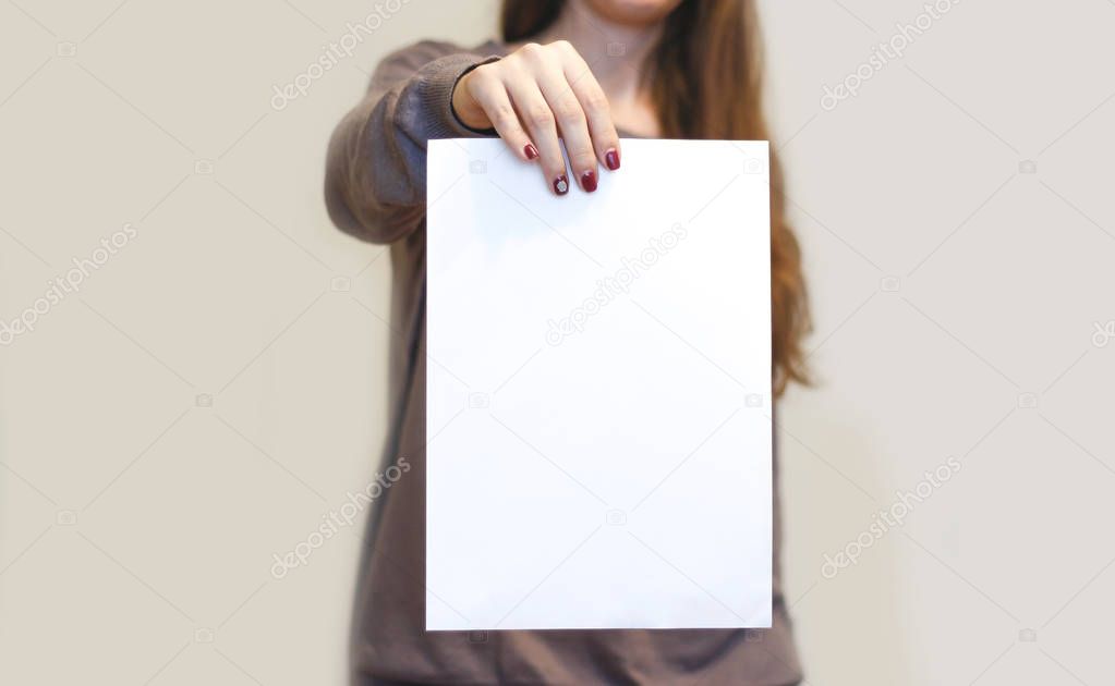 Girl holding white A4 blank paper vertically. Leaflet presentati
