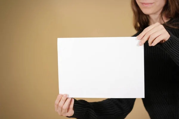 Κορίτσι κρατώντας το λευκό κενό χαρτί Α4. Παρουσίαση οδηγιών. Pamphle — Φωτογραφία Αρχείου
