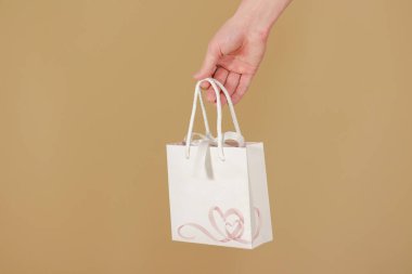 Boş beyaz kağıt hediye çantası elinde tutan sahte yürekleri. 