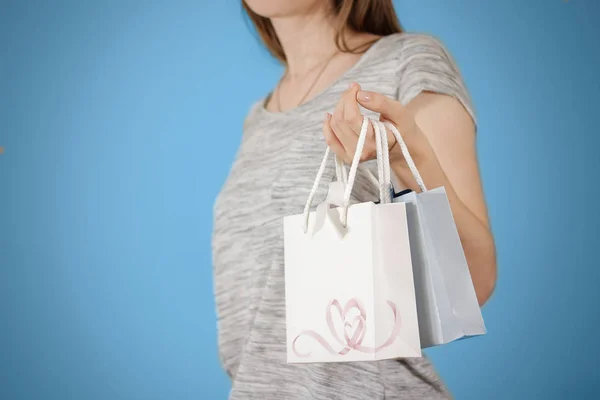 Chica sosteniendo en la mano en blanco dos bolsa de regalo de papel con corazones burla u —  Fotos de Stock