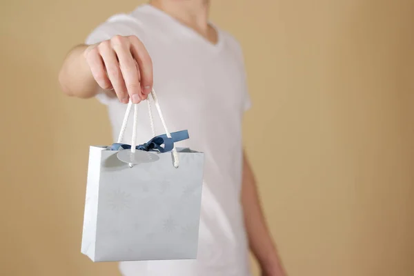 Hombre sosteniendo en la mano en blanco bolsa de regalo de papel azul se burlan. Vacío pac — Foto de Stock