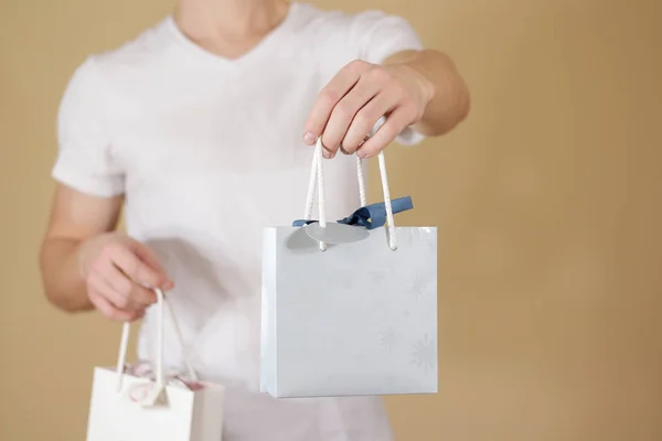 Hombre sosteniendo en la mano en blanco dos bolsa de regalo de papel se burlan. Envase vacío —  Fotos de Stock