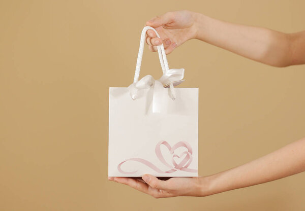 Blank white paper gift bag with hearts mock up holding in hand. 