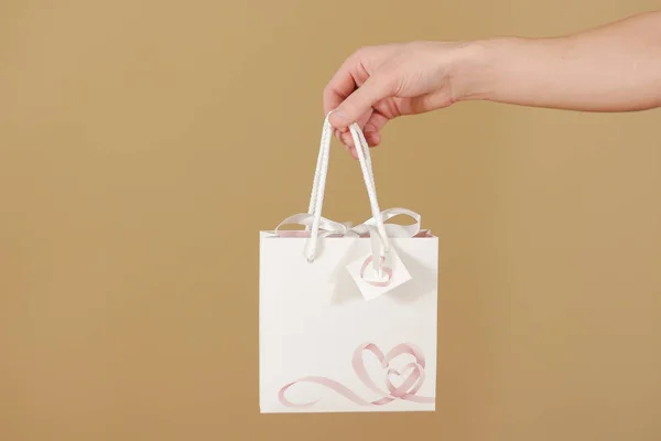Biała kartka papieru prezent torba z serca makieta trzymając w ręku. — Zdjęcie stockowe