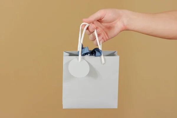 Blank blue paper gift bag with hearts mock up holding in hand. E