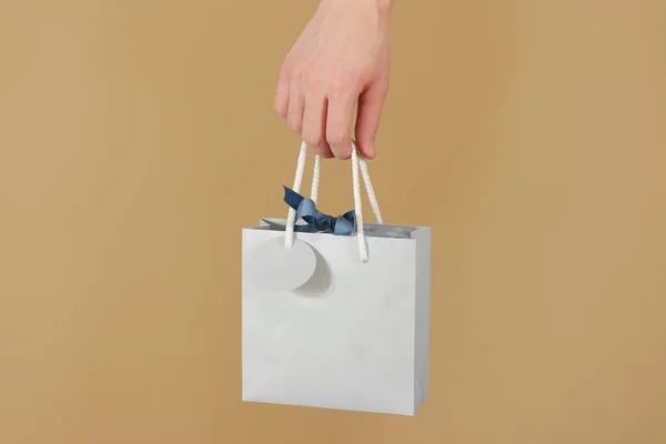 Bolsa de regalo de papel azul en blanco con corazones simulados sosteniendo en la mano. E —  Fotos de Stock