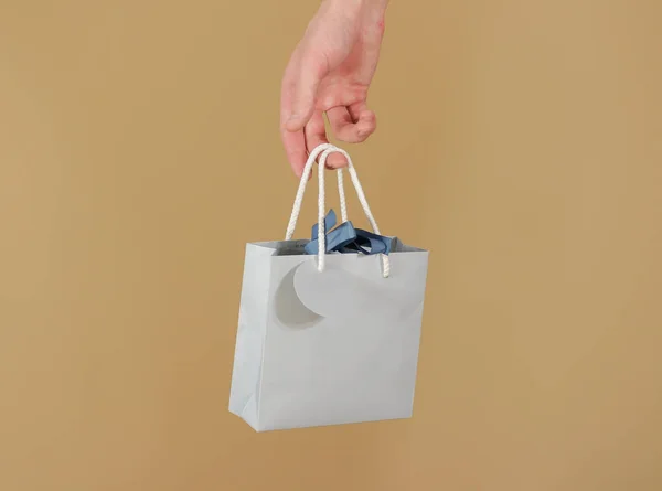 Bolsa de regalo de papel azul en blanco con corazones simulados sosteniendo en la mano. E —  Fotos de Stock