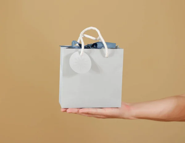 Blanco blauw papier geschenk tas met hart mock up in de hand te houden. E — Stockfoto