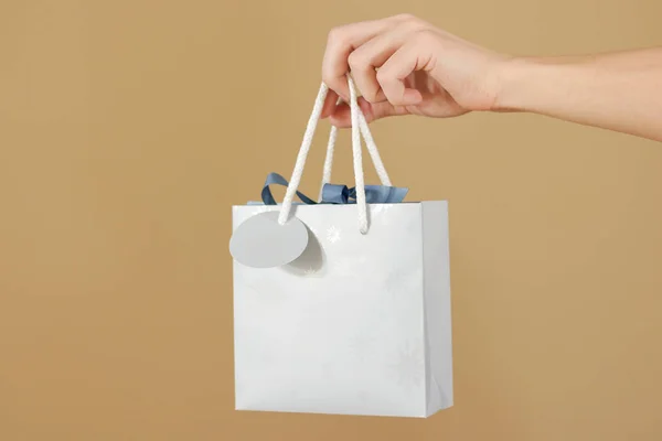 Bolsa de regalo de papel azul en blanco con corazones simulados sosteniendo en la mano. E —  Fotos de Stock