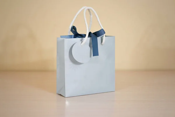 Bolsa de regalo de papel azul en blanco maqueta de pie sobre una mesa de madera. Em. —  Fotos de Stock