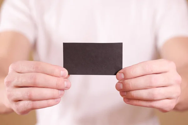 Hombre mostrando tarjeta negra. Presentación del folleto. Folleto cogido de la mano — Foto de Stock