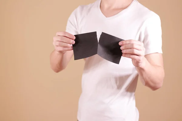 Hombre rasgando un trozo de papel en un folleto de volante negro medio en blanco —  Fotos de Stock