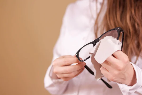 Vrouwen hand schoonmaken glazen lens met geïsoleerde achtergrond — Stockfoto